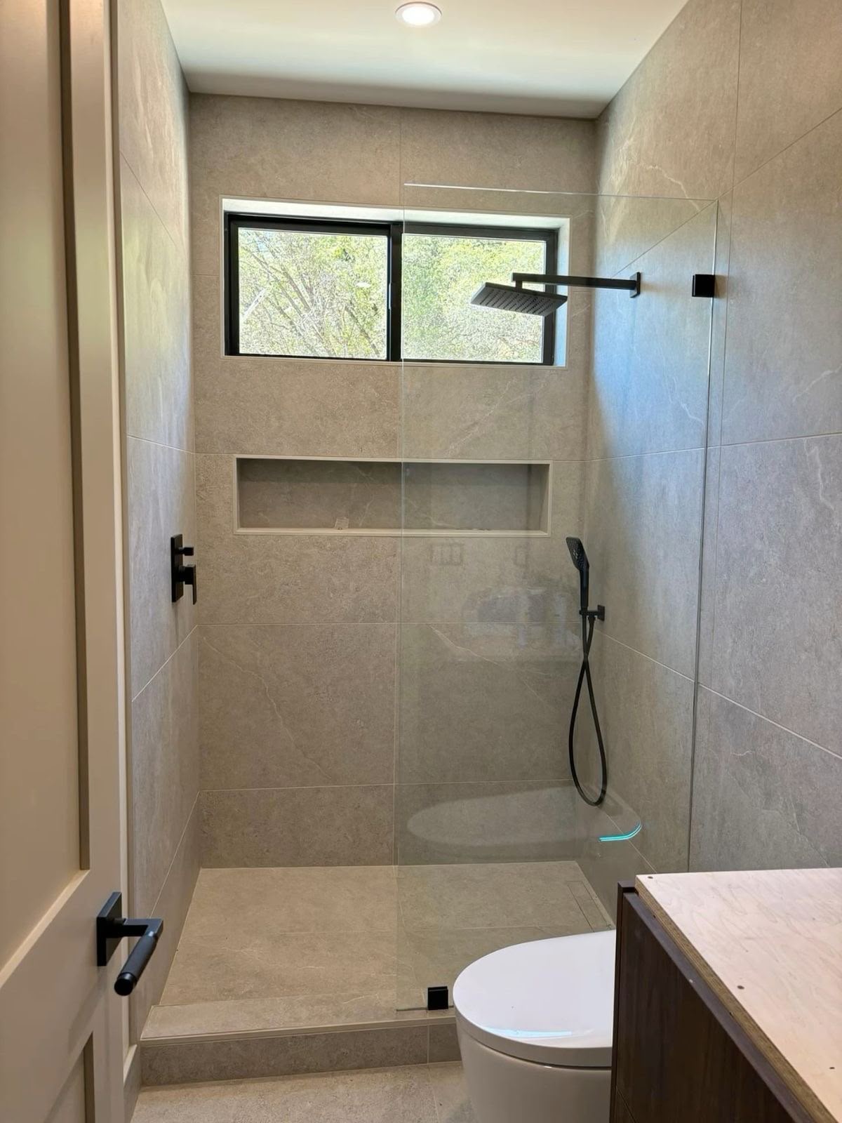 Bathroom renovation with tiled shower area and chrome fittings